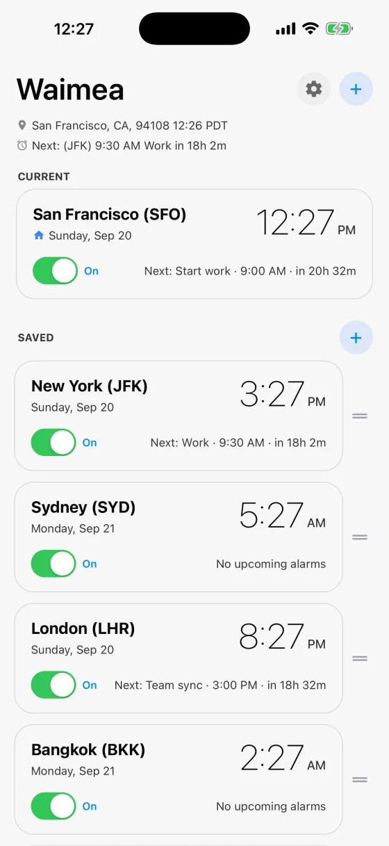 The Waimea home screen. San Francisco under CURRENT, then New York, Sydney, London and Bangkok under SAVED, each card showing its local time, the date there and its next alarm with a countdown.